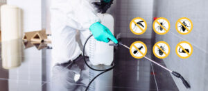Technician in protective gear spraying indoor floor with pest control equipment to eliminate insects and rodents